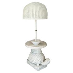 a white table lamp with a basket on top