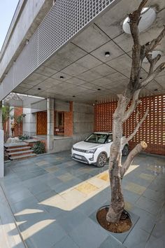 a white car parked in front of a building next to a tree and some stairs