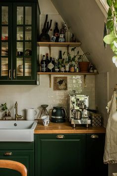 a kitchen with green cabinets and wooden counter tops, along with an old fashioned sink