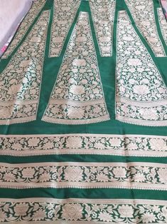 This Banarasi handloom pure silk lehenga is a perfect festive/wedding/occasional wear it enhanced with green color motifs.  Occasion: party wear/wedding  Materials. Pure silk. Unstich  Fabric design - Banarasi  lehenga  Pattern: paisley/buti motifs.  Borders: yes  Border type: Zari  Zari type: golden zari  Fabric length with blouse and with dupatta.  Borders is 6.5 meters  Blouse: 0.85 Meters  No of kali: 18 Size of kali 42 inch  No of border in dupatta 9 Green Lehenga With Pallu In Silk, Green Silk Lehenga With Pallu Detail, Green Silk Lehenga With Pallu, Green Raw Silk Lehenga With Resham Embroidery, Green Silk Semi-stitched Lehenga, Festive Green Silk Lehenga, Green Silk Choli For Wedding, Green Silk Lehenga For Wedding, Green Silk Wedding Choli