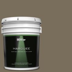 a bucket of behr marquee on a green background