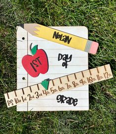 a ruler with an apple on it sitting in the grass