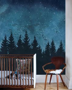 a baby's room with a crib and night sky mural