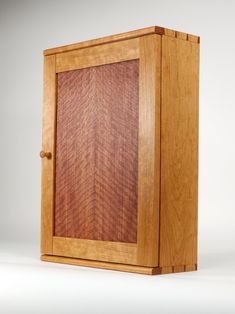 a wooden cabinet with an arrow pattern on the front and bottom panel, made out of wood