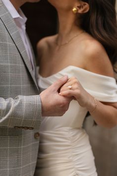 a man and woman holding hands while standing next to each other