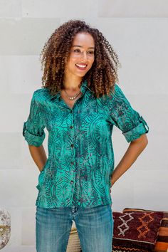 Designed by Galuh Kenanga, this beautiful blouse showcases hand-stamped batik in greens and blues. She works in rayon to craft the long-sleeved shirt with its hi-low hem. The top closes with coconut shell buttons. Irish Wool Sweaters, Irish Fashion, Batik Design, Button Blouse, Shell Buttons, Coconut Shell, Beautiful Blouses, Green Blouse, Glyphs