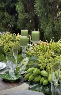 the table is set with green grapes and greenery for an outdoor dinner or party