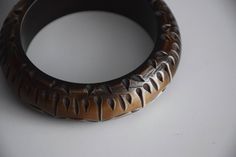 Vintage chunky plastic brown bangle bracelet, from the 80s / 90s era The bangle is made to resemble a bone bangle with purposefully made scratches and imperfections and fading of the brown color into beige Approx. measurements: Diameter (on inside) - 2.65 inches / 6.75 cm Height - 0.85 inches / 2.2 cm Condition: Very good vintage condition! Handmade Brown Bohemian Bangle, Handmade Bohemian Brown Bangle, Bohemian Handmade Brown Bangle, Brown Bakelite Bangle Bracelet, Vintage Carved Brown Bracelets, Vintage Brown Carved Bracelets, Brown Carved Bangle Bracelets, Vintage Bangle Bracelets, Plastic Bangles