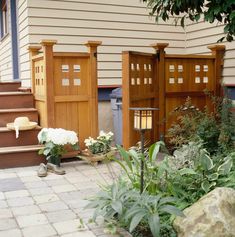 some flowers are sitting on the ground in front of some wooden doors and steps that lead up to a house