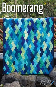 a blue and green quilt with the words boomerang written in white on it