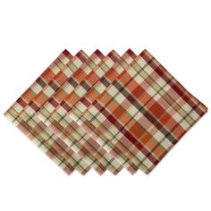 six orange plaid napkins sitting on top of each other in front of a white background