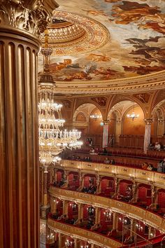 an ornately decorated auditorium with chandeliers and painted ceilinging is seen from the balcony