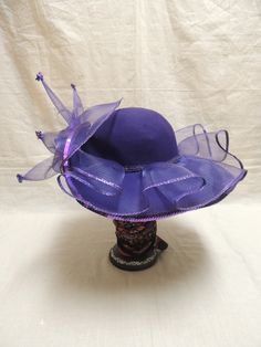 Vintage Purple Red Hat Society in Wool and Tulle with Sequins. This is a vintage Red wool hat society hat and is one size fits all. A beautiful purple floppy hat with brim turned up in the front, decorated with purple tulle, a purple sequined applique and tiny sequined at the end of each bough of tulle. The Red Hat Society is an international social organization that was founded in 1998 in the United States for women age 50 and beyond, but now open to women of all ages. Its main purpose is to pr Fitted Purple Hat With Short Brim, Vintage Purple Hat With Short Brim, Vintage Short Brim Purple Hat, Purple Short Brim Top Hat For Summer, Purple Wide Brim Top Hat For Summer, Wide Brim Felt Hat For Party, Adjustable Purple Felt Hat With Short Brim, Wide Brim Felt Hat For Parties, Purple Top Hat For Royal Ascot