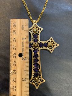 24 karat gold plated, Purple and gold crystal cross with an 18 inch chain. Gold Rhinestone Cross Pendant Necklace, Gold Metal Cross Pendant Jewelry, Gold Metal Cross Jewelry, Gold Cross-shaped Metal Jewelry, Gold Metal Crucifix Cross Necklace, Gold Elegant Metal Cross Necklace, Elegant Gold Metal Cross Necklace, Elegant Gold Cross Necklace, Gold Metal Cross Necklace With Adjustable Chain