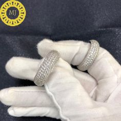 two wedding rings are sitting on top of a glove