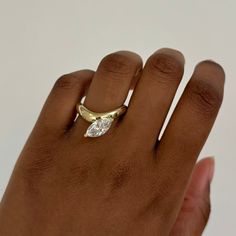 a woman's hand with a diamond ring on top of her left hand,