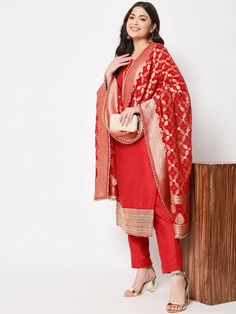 This is a beautiful 3-piece suit set. It comes with straight cut kurta with embroidery detailing on neck & sleeves has 3/4th sleeves, round neck & calf length teamed with solid straight pants and a georgette banarasi dupatta. 3-piece set Color- Red Work- Embroidery work on neck & sleeves Kurti Length - 46 inch Kurta Fabric-Cotton Silk Bottom Fabric -Cotton Silk Dupatta Fabric - Georgette Banarasi dupatta Sleeves-3/4th Sleeves Neck-Round Neck Care - Dry Clean Sleeves Kurti, Brocade Suits, Red Kurti, Suit Neck Designs, Suit With Jacket, Heavy Dupatta, Banarasi Suit, Red Kurta, Banarasi Dupatta