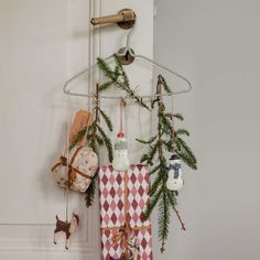 a christmas decoration hanging from the side of a door with bells and ornaments on it