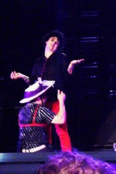 two people are performing on stage with one holding the other's leg in the air