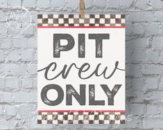 a sign that says pit crew only hanging on a brick wall