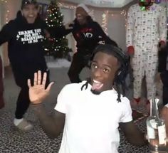 a group of young people dancing in a living room with christmas decorations on the walls