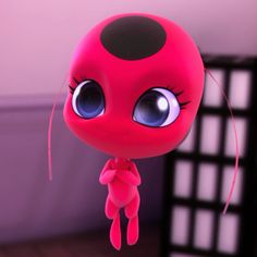 a red toy with big eyes hanging from a string in front of a black and white wall