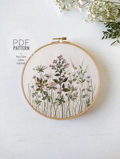 an embroidery pattern with wildflowers on it and some white flowers in the background