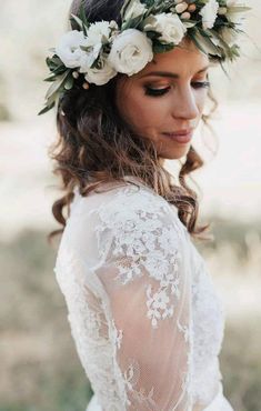 a woman with flowers in her hair wearing a white dress and flower crown on her head