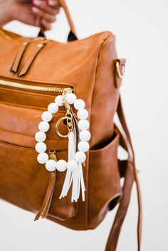 meet our customer-favorite ivy keychains’s funky younger sister - the sage wooden keychain. these bold bracelet keychains are just like our bestselling ivy’s, but with the addition of brightly colored beads and tassels. the sage comes in 7 colors ranging from neutral to neon, so there’s one for everyone! Adjustable White Beaded Bracelet For Everyday, Everyday White Round Bead Bracelets, White Round Beads Bracelets For Everyday Use, White Beaded Jewelry For Everyday Use, White Beaded Everyday Jewelry, White Jewelry With Lobster Clasp For Everyday Use, White Adjustable Wristlet With Key Leash, Adjustable White Wristlet With Key Leash, White Bag Charm Keychain For Everyday Use