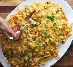 a person is cutting into some food on a plate with a knife and fork in it