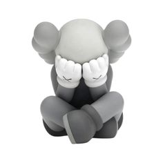 a gray and white figurine sitting on the ground with his hands to his face