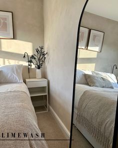 a bed room with two beds and a mirror on the wall next to each other