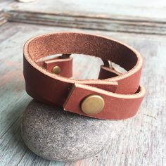 "This double wrap statement bracelet features 1/2\" strips of genuine leather and a 1 1/2\" solid o-ring secured with 2 antique brass rivets. Each piece is dressed with our homemade beeswax mixture. Secures easily with a matching snap. I use only genuine U.S. tanned leather from either Horween (Chicago) or Wickett and Craig (Pennsylvania). The leather will age beautifully, become buttery soft and develop fabulous character over time. Each piece is dressed with our homemade beeswax mixture. Color Adjustable Leather Wrap Bracelet For Everyday Wear, Leather Strap Cuff Bracelet For Everyday, Everyday Leather Cuff Bracelet, Everyday Leather Bracelet With Waxed Finish, Adjustable Leather Strap Wrap Bracelet For Everyday, Adjustable Leather Cuff Bracelet For Everyday, Adjustable Cuff Leather Bracelet For Everyday, Adjustable Rustic Leather Bracelet For Everyday, Rustic Adjustable Leather Bracelet For Everyday