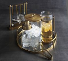 a tray with drinks and glasses on it next to a metal rack that holds ice cubes