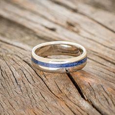 a close up of a wedding ring on a wooden table with wood grained background