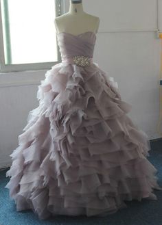 a dress is on display in front of a mannequin wearing a gown with ruffles