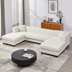 a living room with a sectional couch and coffee table on the rug in front of it