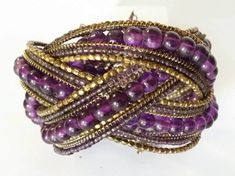 Vintage On Esty Boho Genuine Amethyst Gemstone Beaded Brass Memory Wire Wide Cuff Multi Strand Woven Bracelet Bracelet is Woven brass wire stretch with 21 strands! Large Round Genuine Amethyst Beads. Amethyst and Brass seed Beads!  MEASUREMENTS 9 inches Length 2.5 inches Width Perfect Condition! Sorry No returns or returns Insurance OR Special shipping  CAN BE ACCOMMODATED   Ask before order :) Adjustable Purple Bohemian Cuff Bracelet, Bohemian Purple Bracelets For Party, Bohemian Purple Bracelet For Party, Bohemian Purple Bangle, Handmade Bohemian Purple Bangle, Bohemian Purple Crystal Bracelet For Party, Purple Beaded Bangle Bracelets For Party, Purple Jewelry With Gold Beads For Party, Purple Gold Beaded Party Jewelry