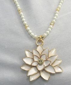 Free domestic shipping, most places USPS 3 day priority mail where possible, otherwise standard post shipping is included in the price of this lovely lotus flower with beaded necklace. I was drawn to this delightful lotus flower charm with the delicate cream color and light citron rhinestone center, so I really wanted to create something of great beauty. The lotus flower pendant measures approximately 1 1/4" in diameter, and the approximate 22" long beaded necklace, I selected gorgeous cream colored iridescent glass beads, sparkling gold glass beads, with tiny sparkling citron beads as an accent, and it is finished with a lobster claw clasp. With the lotus flower there are many different meanings associated with it: purity, beauty, rebirth, the sun, to name just a few. As you wear this lot Spiritual White Flower Necklaces, Gold Pearl Flower Necklace, Gold Pearl Necklace With Flower Charm, Gold Beaded Necklaces With Flower Charm, Gold Beaded Necklace With Flower Charm As Gift, Gold Beaded Necklace With Flower Charm For Gift, Gold Beaded Necklaces With Flower Charm As Gift, Gold Pearl Flower Necklace For Gift, Gold Flower Necklace With Round Beads