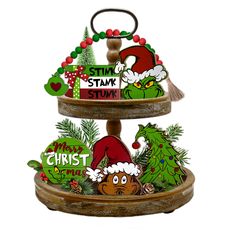 three tiered christmas decoration with the grin on it's top and other decorations