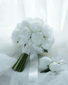 a bouquet of white flowers sitting on top of a bed