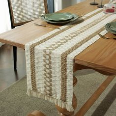 the table is set with plates and silverware on it, along with a lace runner