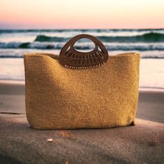 a purse sitting on top of a beach next to the ocean