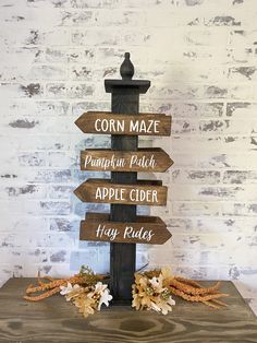 a wooden sign that says corn maze, pumpkin patch, apple cider and hay rakes