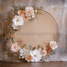 a round frame with flowers and greenery on the top is sitting on a table