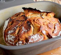 a loaf of bread sitting in a pan on top of a wooden table