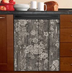 a kitchen with wooden cabinets and black counter tops, white flowers on the cabinet doors