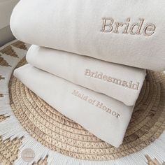 three pillows stacked on top of each other with the word bride embroidered on one pillow