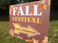 a sign that says fall festival with an arrow pointing to the left and trees in the background