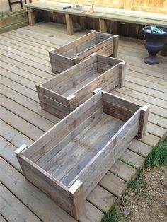 three wooden planters sitting on top of a wooden deck